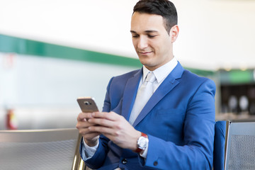 Naklejka na ściany i meble Businessman using the phone at the airport