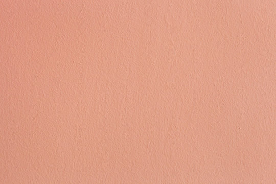 Abstract orange painted wall. Pink plaster colored texture