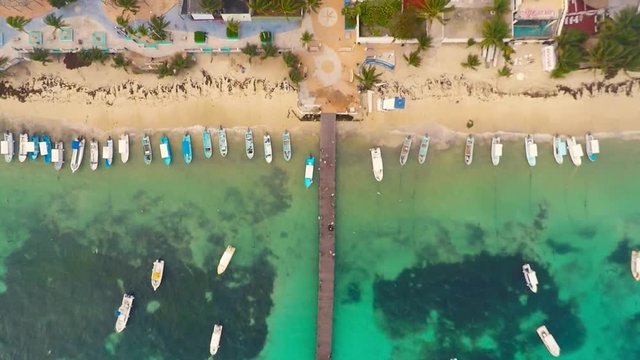 Top view on beach and People walking on wooden bridge. Coast of Caribbean Sea in Puerto Morelos, Yucatan, Mexico