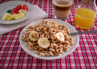 Cereal Bowl with coffee, orange juice and fruit over picnic tabletop 