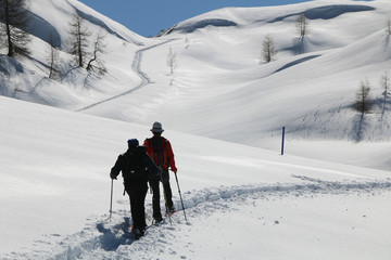 Fototapeta na wymiar Hiking on snowshoes on a trail. Chamois, Valle D'Aosta, Italy.