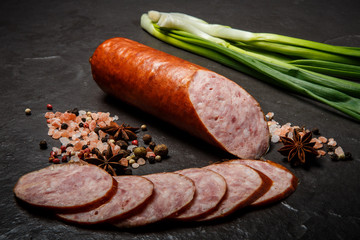half of smoked ham sausage with sliced pieces and green onions