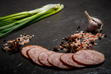 sliced pieces of smoked ham sausage with green onions and garlic