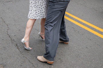 Legs and feet of male and female couple demonstrating dance moves on the street