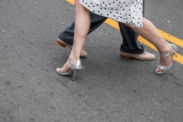 Legs and feet of male and female couple demonstrating dance moves on the street