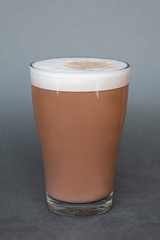 large transparent glass filled with cold summer drink coffee with milk photographed on the isolated gray background picture for the menu