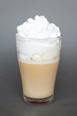 large transparent glass filled with cold summer drink coffee with milk photographed on the isolated gray background picture for the menu
