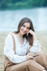 Girl outdoors texting on her mobile phone. Girl with phone. Portrait of a happy woman text sms message on her phone. © Nomad Pixel
