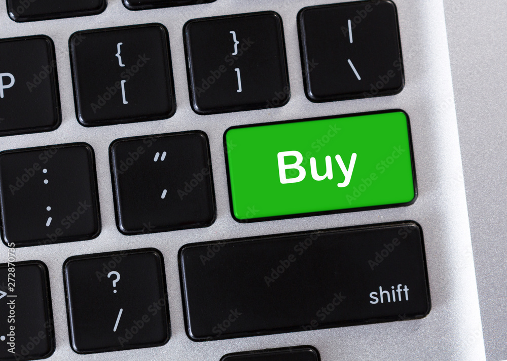 Aufkleber word buy on green button of computer keyboard
