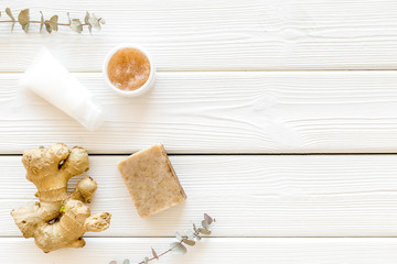 Scrabs and creams for natural cosmetic set with herbs and ginger on white wooden background top view mock up