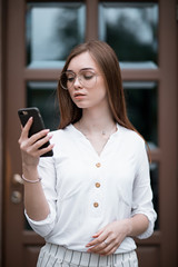 beautiful young woman in a blouse with a phone. businesswoman