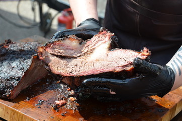 a big piece of freshly prepared grilled meat the chef cuts. Fresh grilled meat. Grilled beef steak medium rare on wooden cutting board