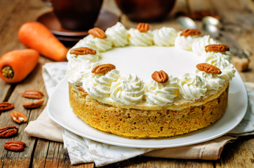 carrot cake cheesecake with pecan on a wood background