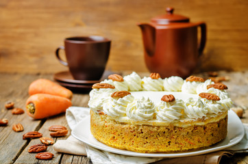 carrot cake cheesecake with pecan on a wood background
