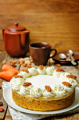 carrot cake cheesecake with pecan on a wood background