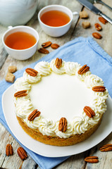 carrot cake cheesecake with pecan on a wood background