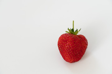 Red strawberry shot close-up on a white background. Isolate, macrophoto.