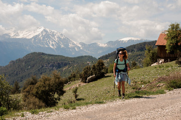 Female hiker travelling near road in hills