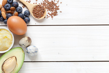 Fototapeta na wymiar Ketogenic food concept with healthy fats: avocado, nuts, butter, berries, eggs, cheese.