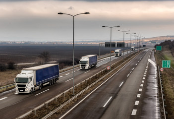 Convoy or Caravan of Tank trucks on a winding Highway through the rural landscape