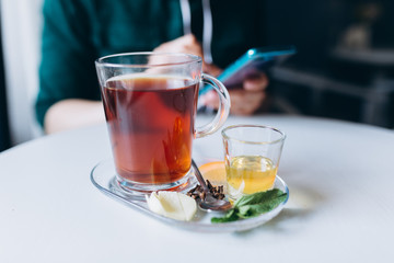 Hot tea in cafe with honey, spices, mint, lemon and ginger. Breakfast, relax concept
