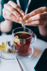 Girl drinking hot tea in cafe with honey, spices, mint, lemon and ginger. Breakfast, relax concept