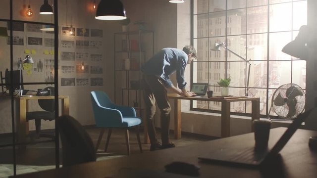 Creative Developer Works on Storyboard in His Studio. Designing Social Apps Design on his Laptop in His Sunny Loft Office. He Puts Notes on Paper and Looks at Modern Urban City View from the Window.