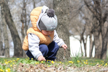 Cute child sitting in the park with flower