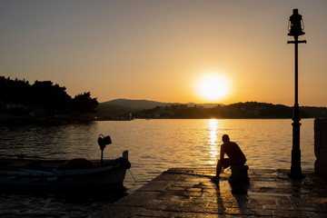 a man looking at sunset at the sea