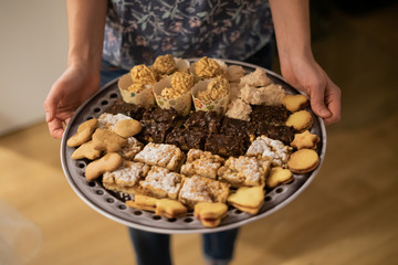 Different pieces of cake and cookies on dinner plate