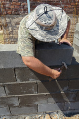 Worker with tools and concrete bricks.