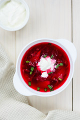 Plate of borsch on a white wooden table. National russian food.