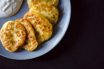 Pancakes with zucchini vegetable and sour cream.