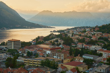 View of the old city from a height at sunset in the background of the mountains in the sky with clouds.