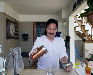 Hispanic man pouring drink at home - 272884320