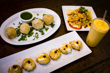 Dahi Puri, Farali Batata Vada, and Bhel Puri Indian Food Served with a Mango Lassi for the Hindu Festival of Navratri