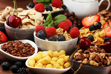 Cereal. Bowls of various cereals, berries and milk for breakfast. Muesli with kids cereals.