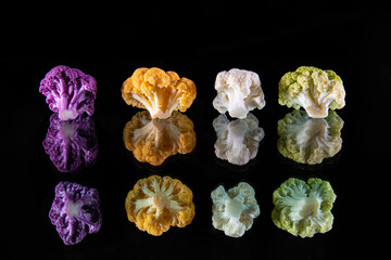 Four bouquets of fresh and colorful cauliflowers - purple, yellow, white and green