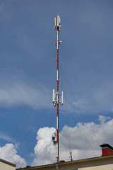 Obraz premium Mobile telephone radio network antennas on the building roof broadcasting signal over the city