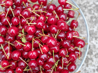 Obraz na płótnie Canvas Ripe juicy red cherries in a transparent plate. A rich harvest of healthy berries. Natural vitamins. Photo view from the top.