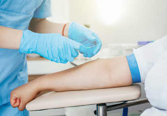 Nurse taking blood sample from patient at the doctors office