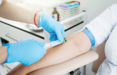 Nurse taking blood sample from patient at the doctors office