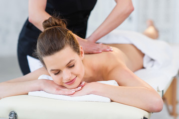 Beautiful caucasian woman during massage in spa salon. - obrazy, fototapety, plakaty
