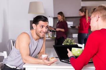 Man discussing with guy in kitchen of hostel