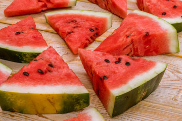 Pieces of watermelon on a wooden background