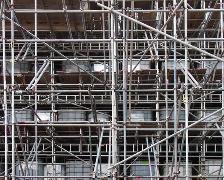 scaffolding on a construction siteshowing ibc water filled intermediate bulk containers used as ballast on each level