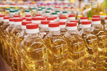 Bottle with sunflower oil on the store shelf, background texture