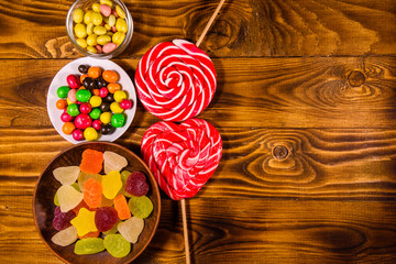 Different sweet candies on a wooden table. Top view