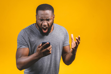 Young african american man using smartphone stressed, shocked with shame and surprise face, angry and frustrated. Fear and upset for mistake.