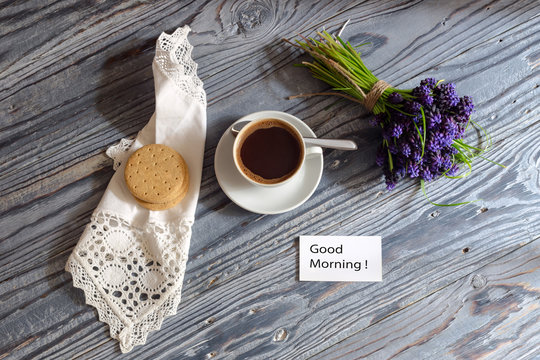 A cup with morning coffee and a bouquet of flowers